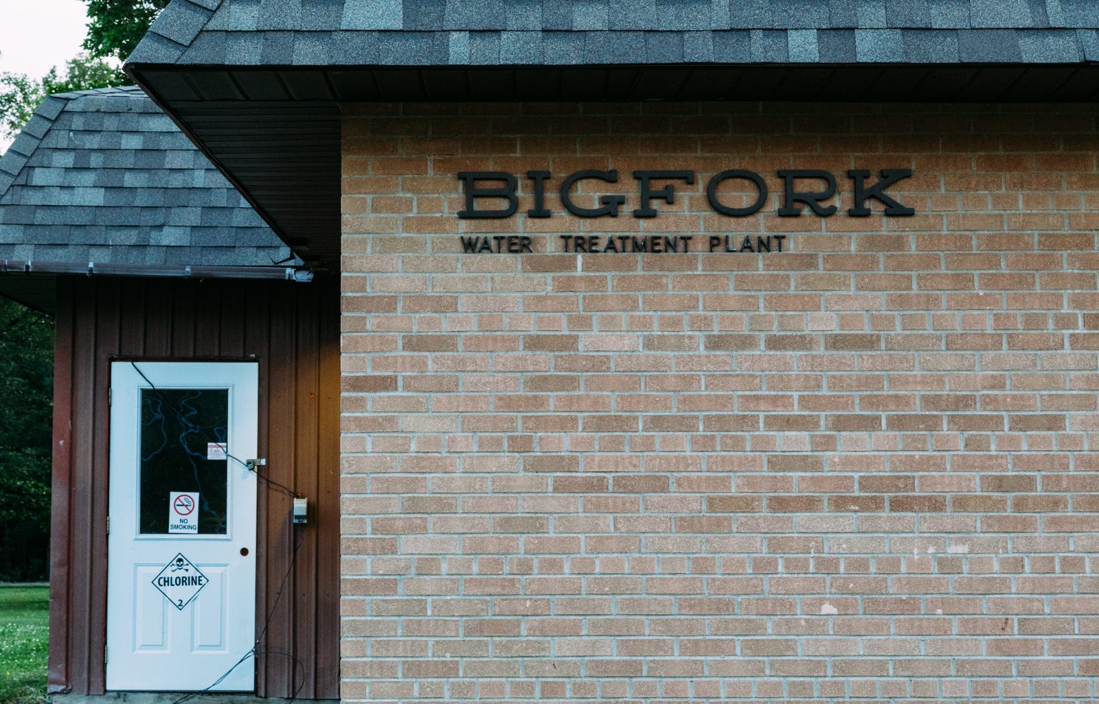 Brick exterior of the Bigfork, Minnesota water treatment plant, with a chlorine warning placard on the entry door
