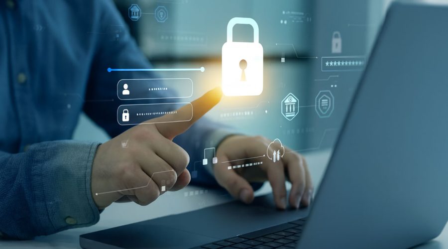 User tapping glowing padlock icon on laptop screen — multi-factor authentication, secure access, and identity protection services by McNallan Technology Solutions Technology for MN businesses