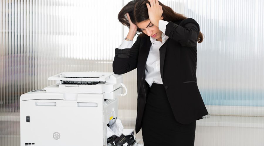 Frustrated business professional with jammed printer — McNallan Technology Solutions Technology provides quick printer repair solutions in Minneapolis, MN